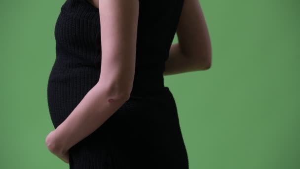 Profil bild av unga vackra gravid affärskvinna mot grön bakgrund — Stockvideo