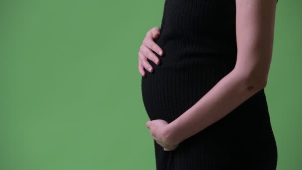 Profil bild av unga vackra gravid affärskvinna mot grön bakgrund — Stockvideo