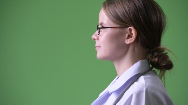 緑の背景にクロマキーに対して若い美しい女医のスタジオ撮影 — ストック動画