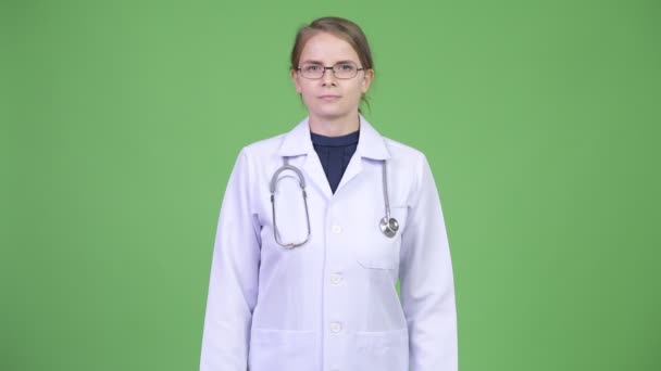 Jovem mulher feliz médico contra fundo verde — Vídeo de Stock