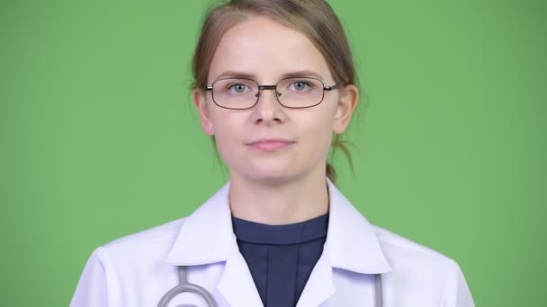 Ευτυχισμένη γυναίκα γιατρός χαμογελώντας ενάντια σε πράσινο φόντο — Αρχείο Βίντεο