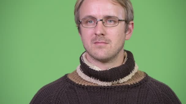 Boğazlı kazak ve gözlük giyerken düşünme sarışın yakışıklı adam — Stok video