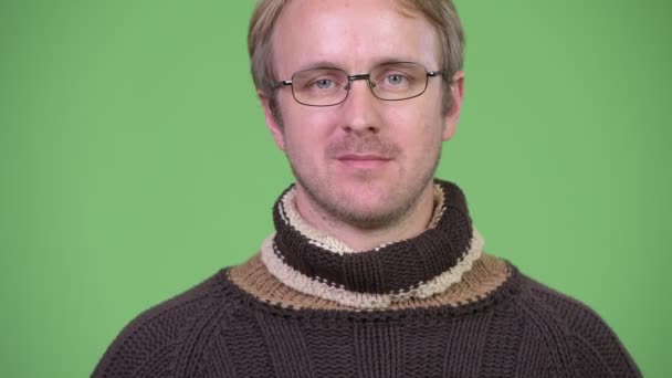Ευτυχισμένος όμορφος άνδρας φορώντας ζιβάγκο πουλόβερ και γυαλιά — Αρχείο Βίντεο