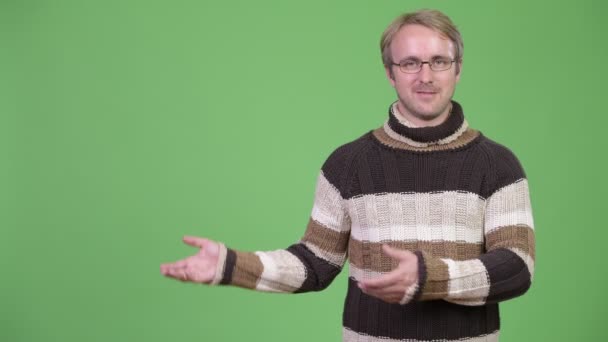 Estúdio tiro de homem bonito feliz mostrando algo — Vídeo de Stock