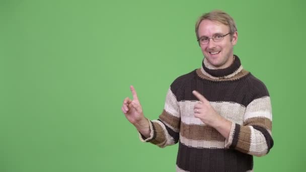 Studio shot of happy handsome man showing something — Stock Video