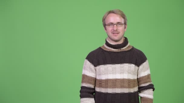 Estúdio tiro de homem bonito feliz pensando enquanto apontando para cima — Vídeo de Stock