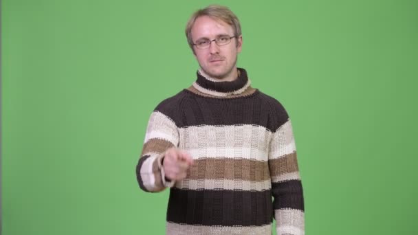 Studio shot of blonde handsome man pointing to camera — Stock Video