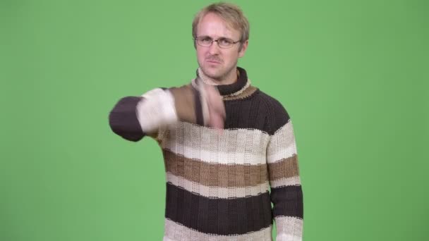 Studio shot of angry man giving thumbs down — Stock Video