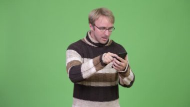 Stüdyo çekim sarışın yakışıklı adam telefonu kullanarak ve şok arıyorsunuz