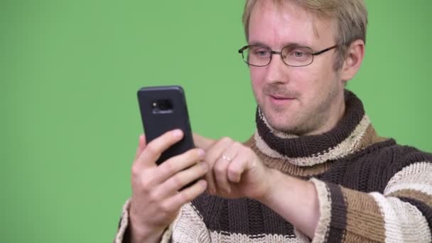 Studio záběr šťastný pohledný muž pomocí telefonu a získání dobré zprávy — Stock video