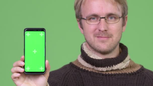 Studio shot of happy handsome man showing phone — Stock Video