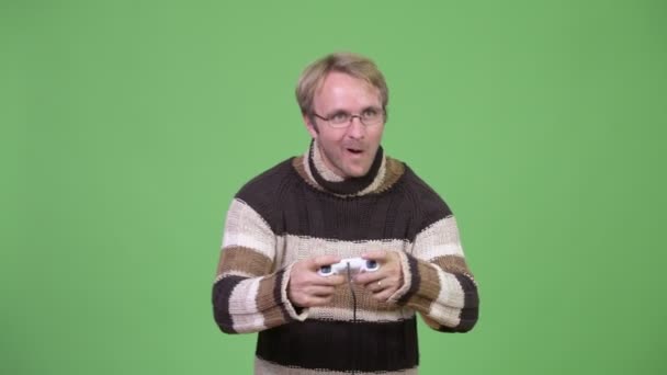 Студійний знімок щасливого красивого чоловіка, який грає в ігри та виграє — стокове відео