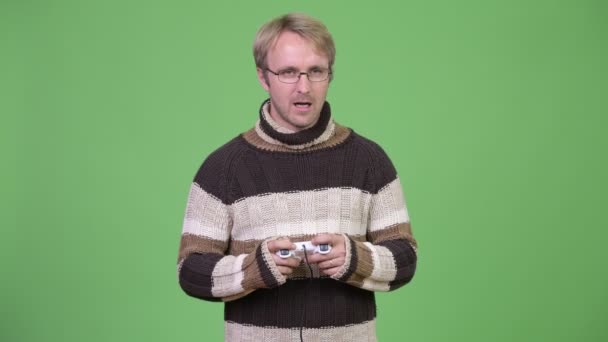 Studio shot of tired man playing games and falling asleep — Stock Video