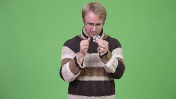 Estudio de tiro de hombre guapo feliz jugando con fidget spinner — Vídeo de stock