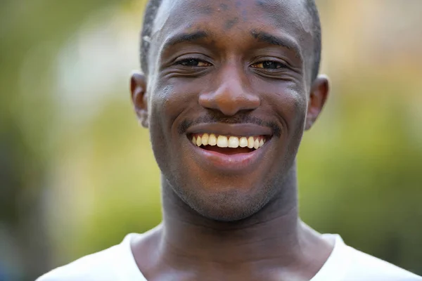 Joven hombre africano feliz sonriendo en las calles al aire libre — Foto de Stock