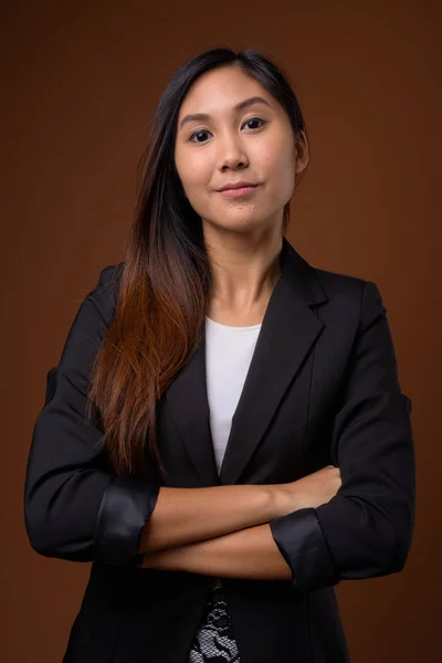 茶色の背景に対して若い美しいアジア女性実業家 — ストック写真