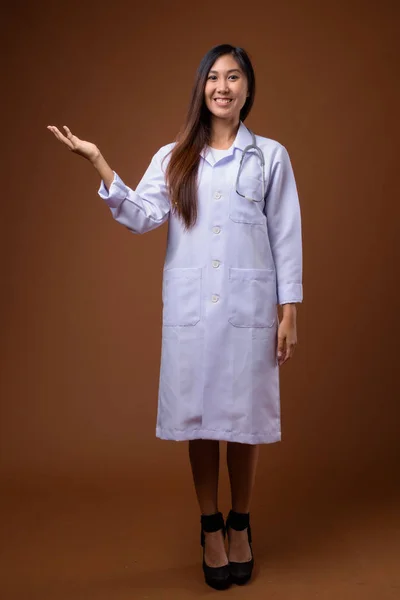 Молода жінка красива Азіатська лікар коричневий тлі — стокове фото