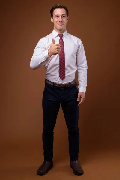 Молодий красивий бізнесмен на коричневому фоні — стокове фото