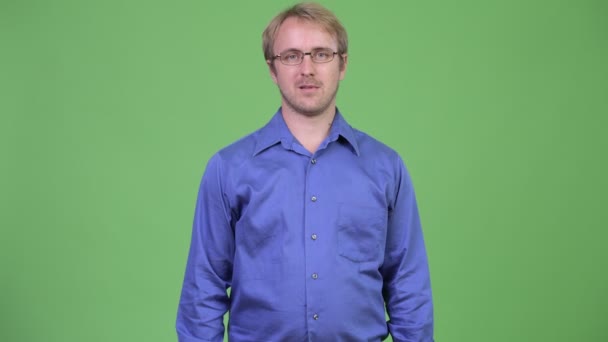 Gelukkig knappe blonde zakenman glimlachend met gekruiste armen — Stockvideo