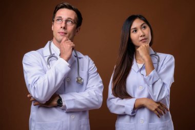 Kahverengi backgrou karşı birlikte iki genç doktor stüdyo çekim