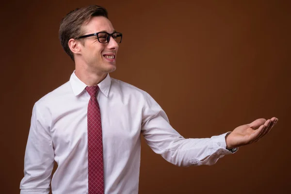 Giovane bell'uomo d'affari che indossa occhiali contro la schiena marrone — Foto Stock