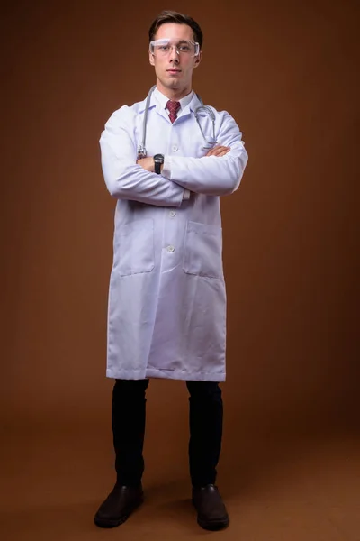 Joven hombre guapo doctor usando gafas protectoras contra bro — Foto de Stock