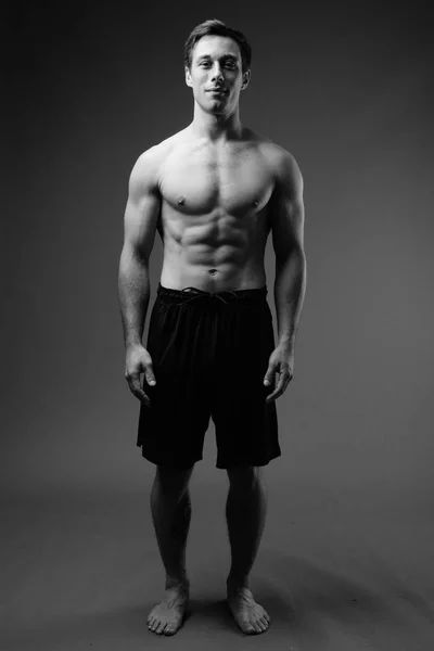 Estúdio tiro de jovem muscular bonito homem sem camisa em preto um — Fotografia de Stock