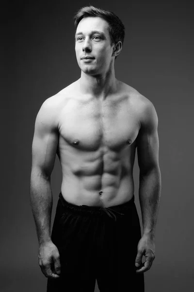 Estúdio tiro de jovem muscular bonito homem sem camisa em preto um — Fotografia de Stock
