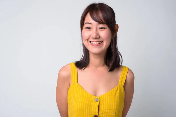 Retrato de una hermosa mujer asiática con vestido amarillo — Foto de Stock