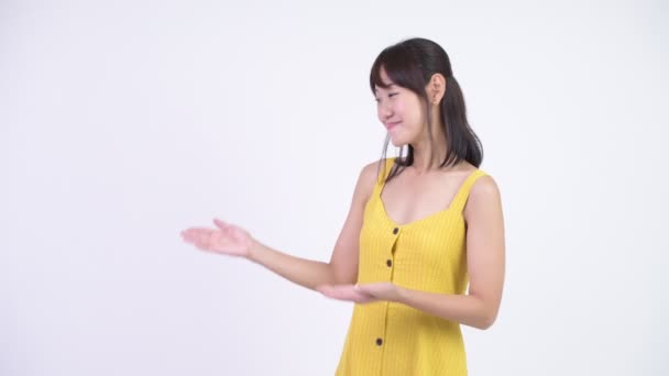 何かを示す幸せな美しいアジアの女性 — ストック動画