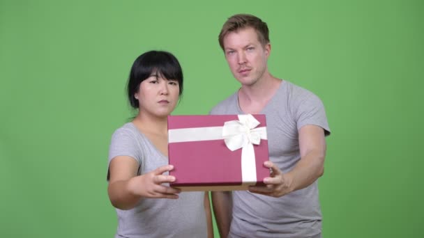 Unga lyckliga multietniska paret ge presentförpackning tillsammans — Stockvideo