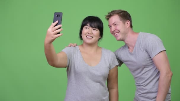 Νεαρό ζευγάρι πολυεθνικό χαμογελώντας ενώ λήψη selfie μαζί — Αρχείο Βίντεο