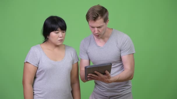 Unga multietniska par använda digitala surfplatta och få dåliga nyheter ihop — Stockvideo