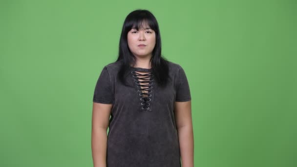 Felice donna asiatica in sovrappeso che punta alla fotocamera — Video Stock