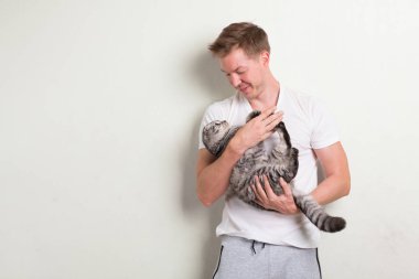 Tutarak şirin kedi gülümseyen mutlu yakışıklı delikanlı