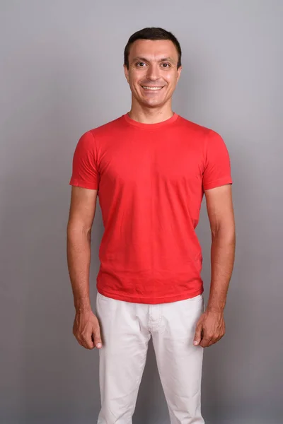 Man wearing red shirt against gray background — Stock Photo, Image