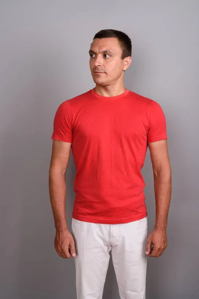 Mann trägt rotes Hemd vor grauem Hintergrund — Stockfoto
