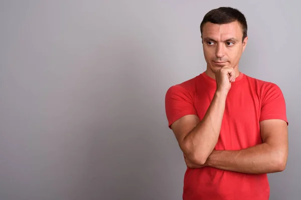 Man wearing red shirt against gray background