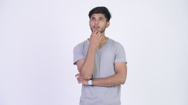 Junge schöne bärtige indische Mann denken, während Sie nach oben schauen — Stockvideo