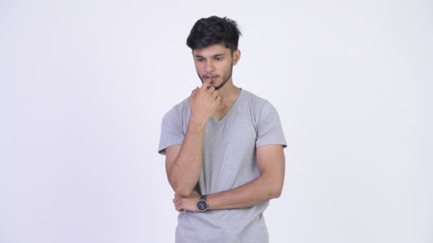 Young serious bearded Indian man thinking — Stock Video