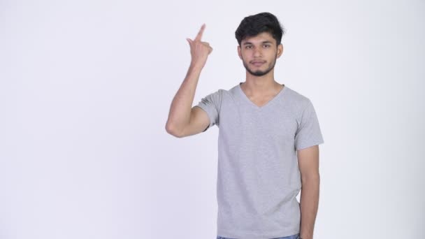 Mladý šťastný indické vousáč prsty a ukazovat něco — Stock video