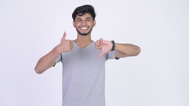 Young bearded Indian man choosing between thumbs up and thumbs down — Stock Video