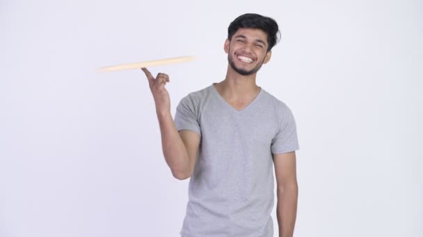 Junger glücklicher bärtiger indischer Mann dreht Tafel auf Fingerspitze — Stockvideo