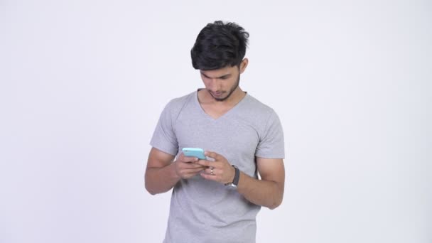 Jeune homme indien barbu heureux en utilisant le téléphone — Video