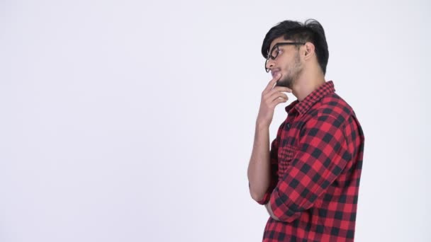 Profile view of young handsome bearded Indian hipster man thinking — Stock Video