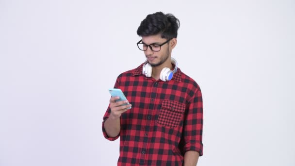 Jonge gelukkig Indiase bebaarde hipster man via telefoon en krijgen goede nieuws — Stockvideo