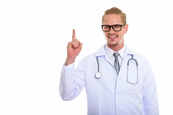 Studio skott av unga lycklig man läkare ler medan pekande fin — Stockfoto