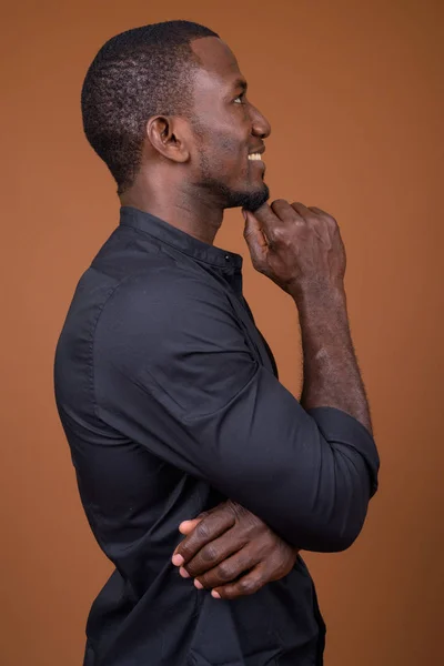 Retrato del guapo empresario africano sobre fondo marrón —  Fotos de Stock