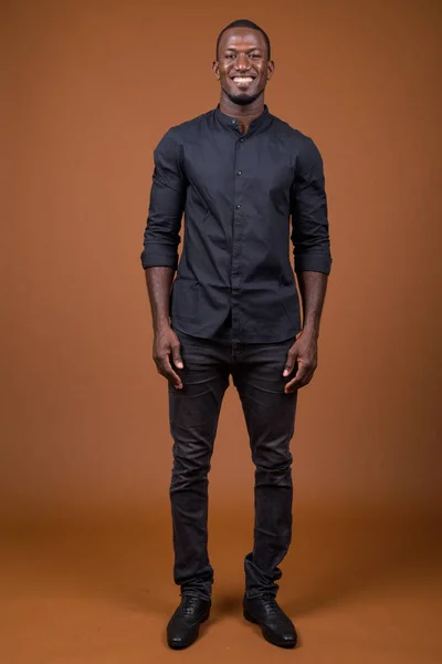 Портрет красивого африканского бизнесмена на коричневом фоне — стоковое фото