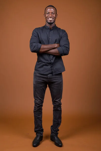 Retrato del guapo empresario africano sobre fondo marrón —  Fotos de Stock
